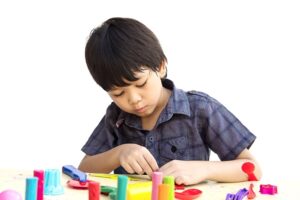 Asian lovely boy preschooler working on problem-solving skills