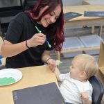 Miss Debany painting Warner's hand